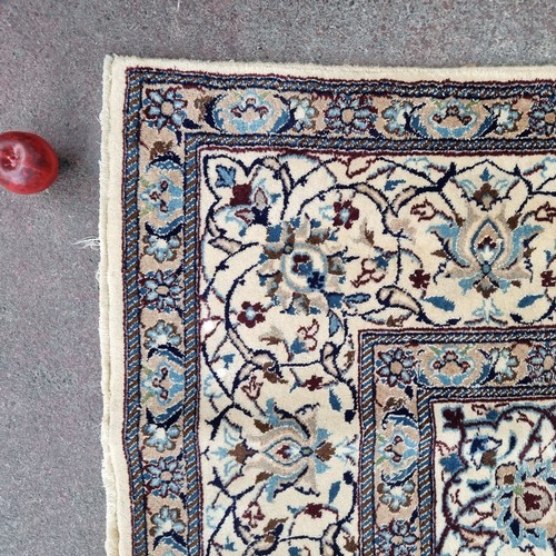 947 - Star Lot: A very large hand knotted wool rug with a highly ornate floral design in shades of cream a... 