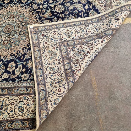 947 - Star Lot: A very large hand knotted wool rug with a highly ornate floral design in shades of cream a... 