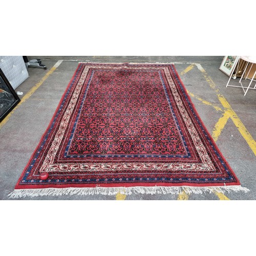 948 - Star Lot: A gorgeous hand knotted wool rug with a foliate motif in jewel tones of red and blue with ... 