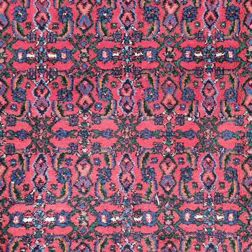 948 - Star Lot: A gorgeous hand knotted wool rug with a foliate motif in jewel tones of red and blue with ... 