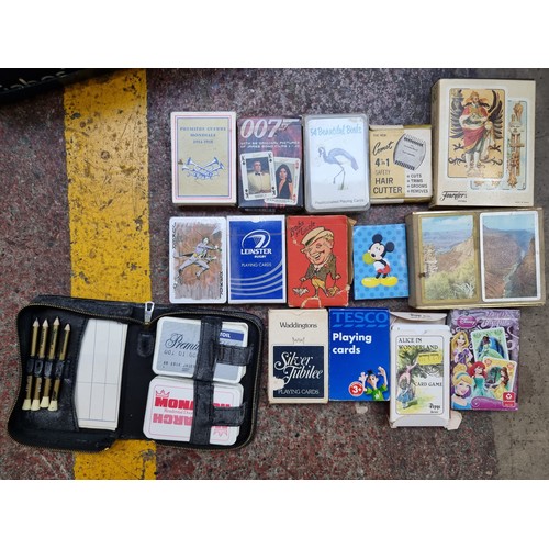 934 - A large collection of vintage playing cards including a 007 example.