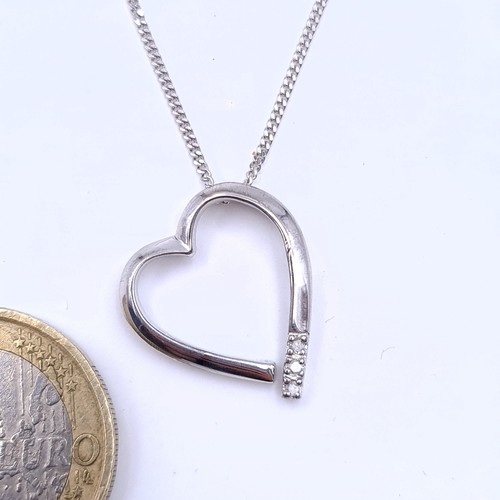 13 - A heart shaped pendant necklace with silver chain set with gem set detailing. Length of chain 42cm.