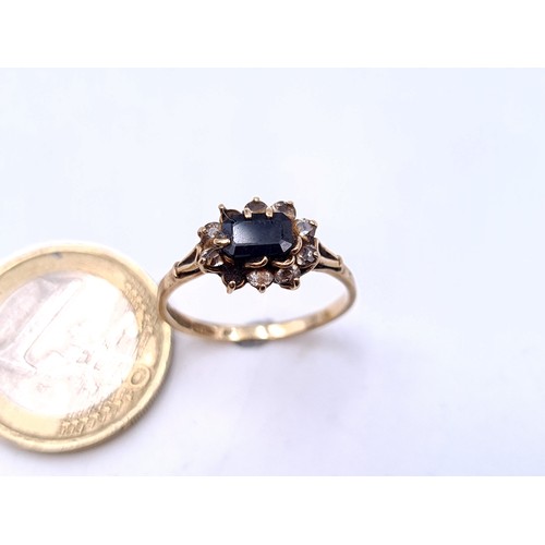 44 - Star Lot : A vintage 9 carat gold set with a Sapphire central stone with gem set surround. Ring size... 