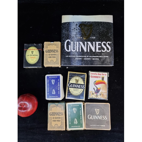 136 - Eight Guinness advertising items including seven decks of playing cards and a hardback book commemor... 