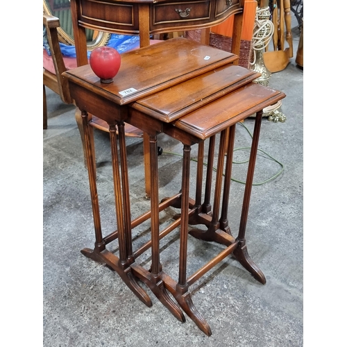 782 - An elegant vintage three-part nesting table held on fluted supports.