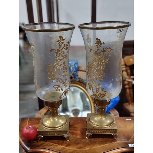 783 - A pair of lavish candle holders with large gilded glass shades held on brass bases. H54cm