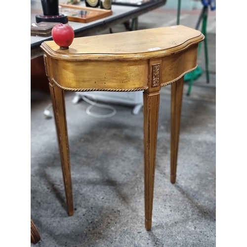 784 - A striking gilded demilune table in the Neoclassical style. With rope twist detail to edge and taper... 