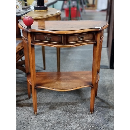 815 - A handsome demilune table with a scroll edge, drawer to front and shelf to base. H76cm x W72cm x D35... 