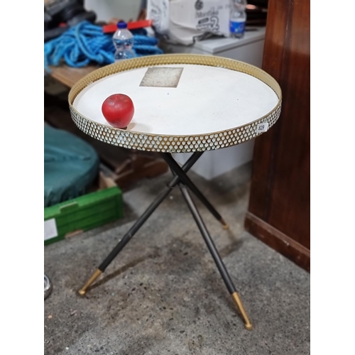 829 - A stylish coffee table with a brass gallery edge and a tripod base finished with brass feet. H62cm x... 