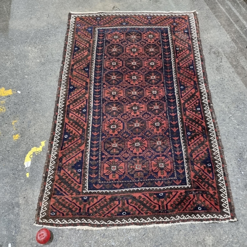 852 - Star Lot : A mid size hand knotted wool rug in muted tones terracotta, brown, cream and navy accent.... 