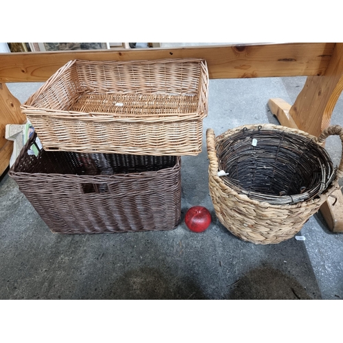 954 - Four wicker baskets including one with handles.