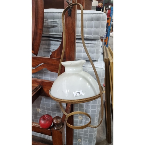 972 - An antique brass framed pendant oil lamp with a milk glass shade. Featuring a beveled brass reservoi... 