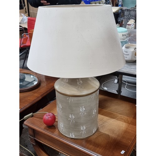 781 - A stylish can style table lamp with a large metal base topped with cream shade. H62cm.