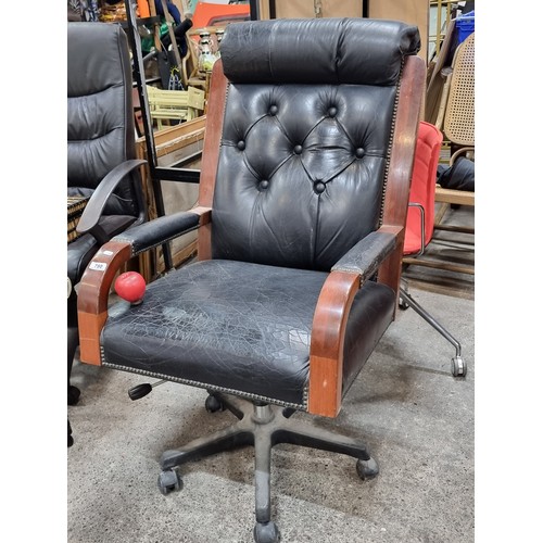 780 - A large  handsome button back swivel leather office chair with a rolled headrest and studded armrest... 