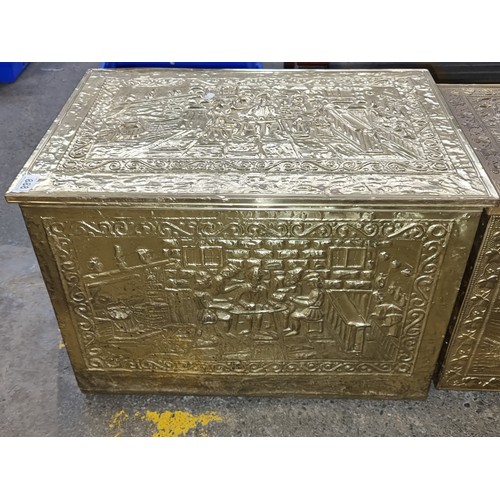 888 - Two vintage brass firewood boxes featuring a tavern and a farming scene. H40cm x W58cm x D35cm.