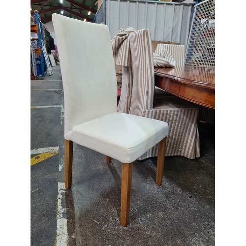 758 - Star Lot : Eight elegant padded dining chairs with wooden legs and cream upholstery. With covers in ... 