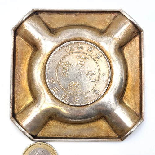 37 - A interesting Chinese coin mounted cigarette ashtray, featuring a swirling dragon motif to centre em... 