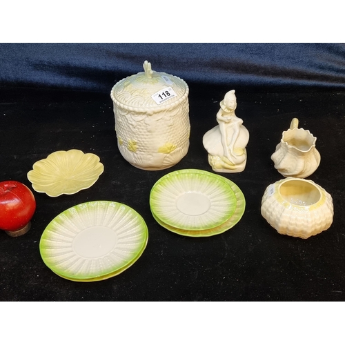 118 - Nine Belleek items including a large lidded jar, a charming figure of a gnome, saucers, a sugar bowl... 