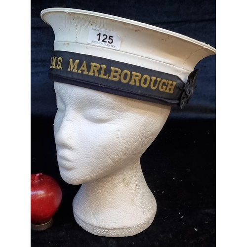 125 - A vintage English H.M.S. Marlborough navy cap. With a chin strap and personal inscriptions from othe... 