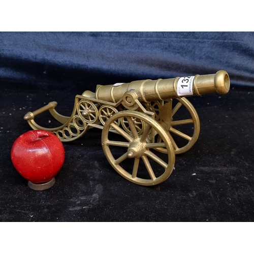 132 - A vintage heavy brass  cannon with articulated features.