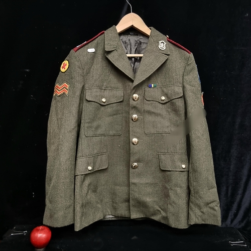 142 - A vintage Irish military jacket dating to 1984. With brass buttons, emblems and sawn-on patches.