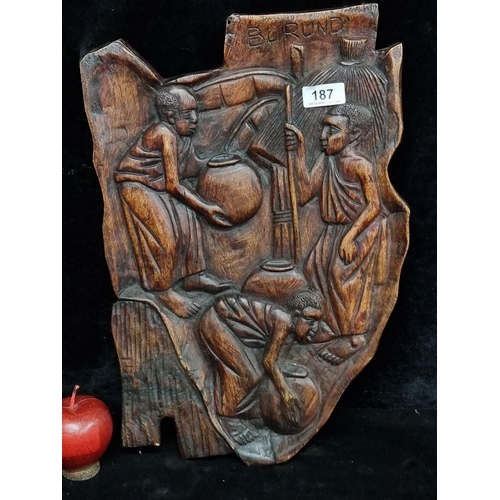 187 - A beautiful hand carved wall plaque depicting traditional African scenes, signed Burundi to top.