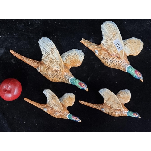 194 - A set of four graduated Beswick flying pheasant wall plaques. Tail damaged to one. Other three in ve... 