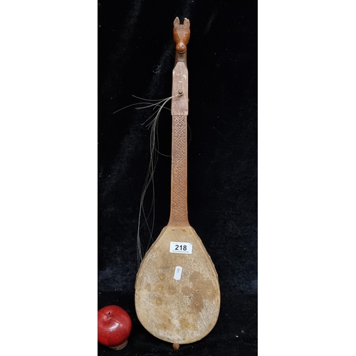 218 - An unusual vintage Serbian gusle instrument with a hand carved wooden frame, a headstock in the form... 