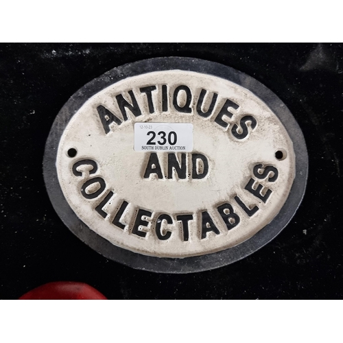 230 - A neatly proportioned heavy cast metal plaque reading antiques and collectables.