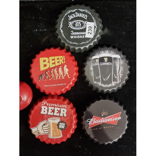 239 - Five oversized advertising bottle caps including Guinness and Budweiser.