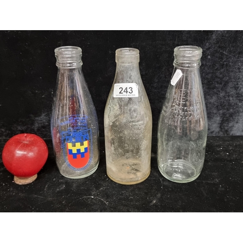 243 - Three vintage milk bottles including a Lucan Diary example and Millennium example.