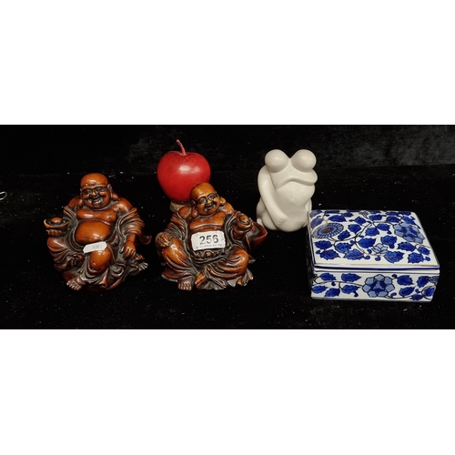 256 - Four items comprising off two wooden Buddha figures signed to base, a lidded trinket dish and a soap... 