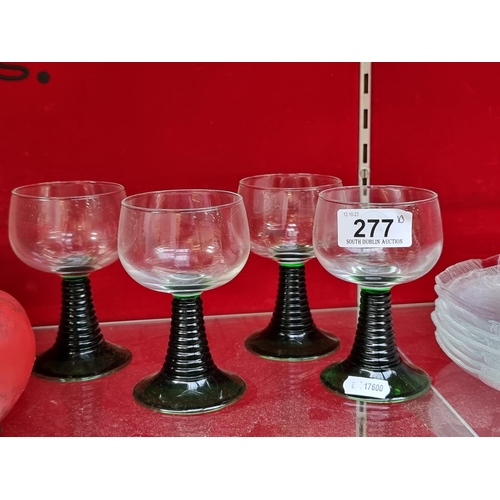 277 - Four stemmed wine glasses with twisted green glass stems. Along with seven glass plates by Arcoroc F... 