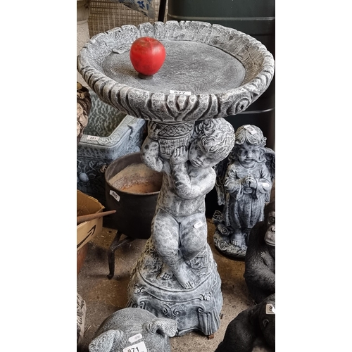 877 - A large striking reconstituted stone garden bird bath with a stem in the form of a cherub. H76cm