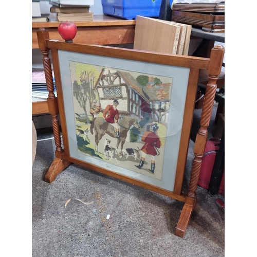 899 - A fire screen featuring an embroidered panel hunters. Housed in a wooden frame with rope twist detai... 