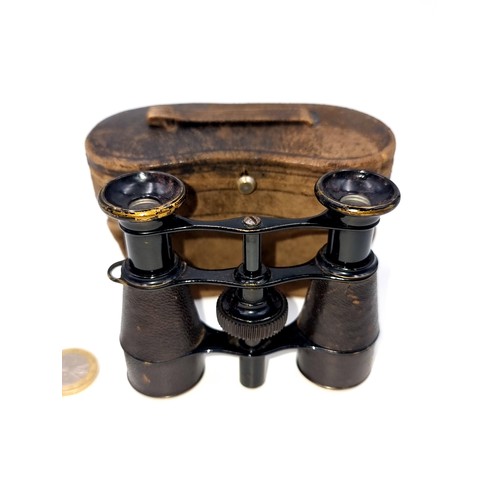 956 - Antique binoculars with a compass to centre. Accompanied by an antique leather case.