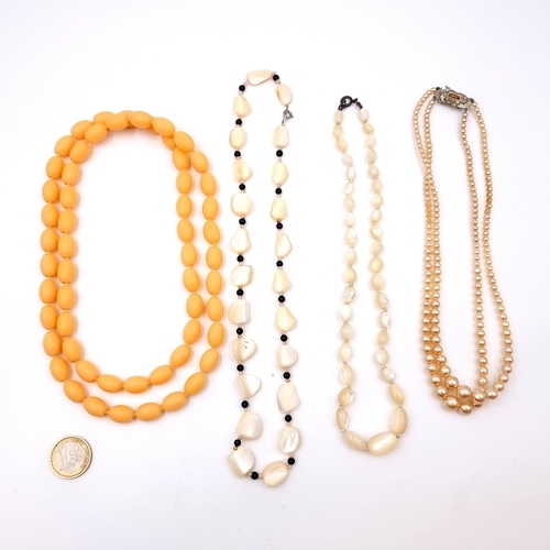 26 - A collection of four vintage dress necklaces, including a double strand pearl necklace with a length... 