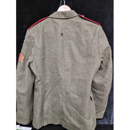 142 - A vintage Irish military jacket dating to 1984. With brass buttons, emblems and sawn-on patches.