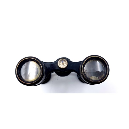 956 - Antique binoculars with a compass to centre. Accompanied by an antique leather case.