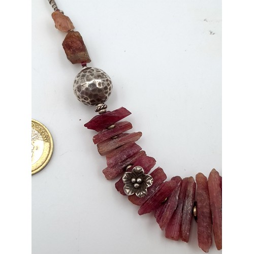 478 - An unusual sterling silver necklace, set with uncut natural Ruby stones and metal ball accents. Leng... 