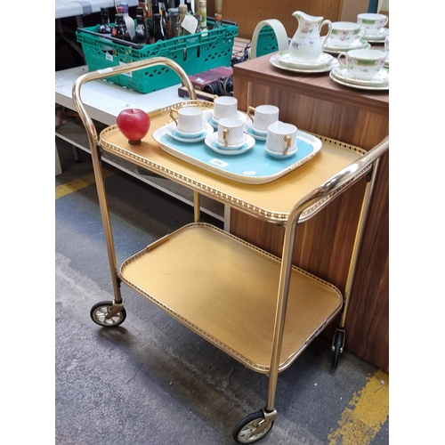 691 - A fabulous retro drinks trolley in a brass finish with lovely pierced sides and four castors.