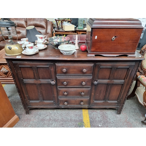 707 - Star Lot: A handsome Mid Century  Ercol sideboard with cabinets revealing shelves and four drawers. ... 