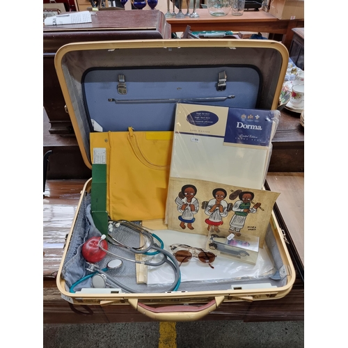 712 - A large retro suitcase bag containing mixed items including 100% cotton fitted single sheet set by D... 