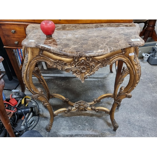 768 - Star lot : A very elaborate console table with a brown marble top held on a profusely carved gilt wo... 