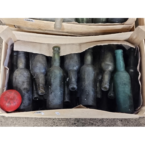 1083 - A crate containing a collection of approx twenty-five antique glass bottles.