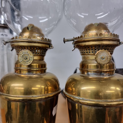 150 - A pair ofBritish made Anchor GNR Brand oil lamps with brass fittings and glass shades.