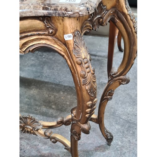 768 - Star lot : A very elaborate console table with a brown marble top held on a profusely carved gilt wo... 