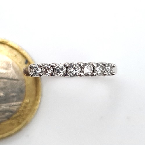 486 - Star Lot : A sparkling example of a seven stone bright Diamond half eternity ring, of .33 carats of ... 