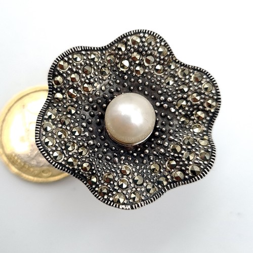 487 - A fabulous sterling silver cocktail ring, set with a central pearl and Marcasite scalloped mount. Ri... 