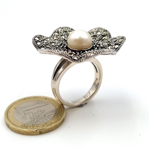 487 - A fabulous sterling silver cocktail ring, set with a central pearl and Marcasite scalloped mount. Ri... 